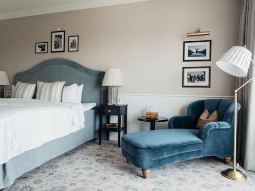 赫尔辛格马利恩尔斯特斯特兰德酒店的一间卧室配有一张床和一张蓝色椅子