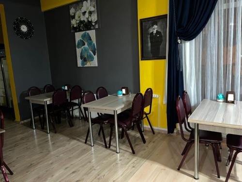 埃迪尔内M.H.T的一间设有桌椅的用餐室和黄色的墙壁