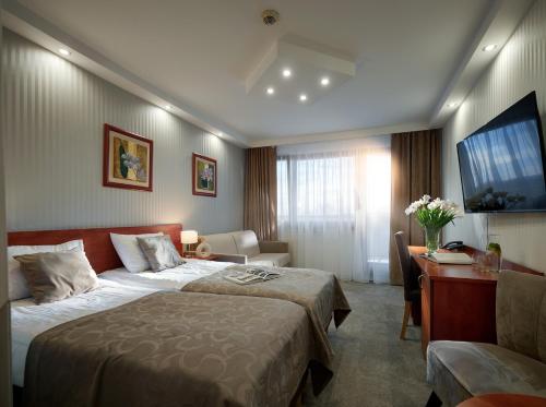 科沃布热格阿尔卡Spa酒店的配有一张床和一张书桌的酒店客房