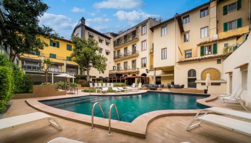 佛罗伦萨克罗齐迪马耳他酒店的一座位于庭院内的游泳池,庭院内有建筑