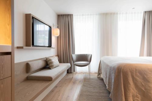 栋堡Hotel Bommelje的配有一张床和一把椅子的酒店客房