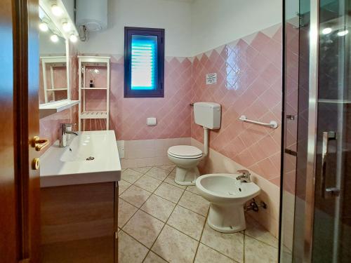 圣特奥多罗Appartamento Trilocale vicino al centro di San Teodoro的粉红色的浴室设有卫生间和水槽