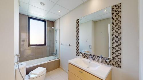 迪拜Primestay - Odora 6BR, Akoya Oxygen的一间带水槽、卫生间和镜子的浴室