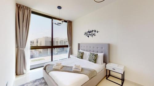迪拜Primestay - Odora 6BR, Akoya Oxygen的一间卧室设有一张床和一个大窗户