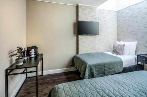 阿姆斯特丹阿姆斯特丹亚特兰蒂斯酒店的酒店客房设有两张床和一台平面电视。
