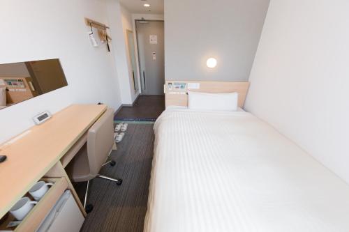 东京东京大冢超级酒店 的小房间设有一张床和一张书桌