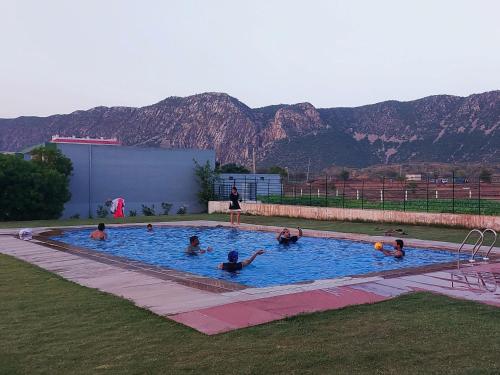 Thāna GhāziThe Sariska Retreat的一群人在一座山地游泳池里