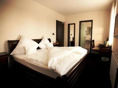 奥特鲁普阿尔索夫兰德酒店的一间卧室配有带白色床单和枕头的床。