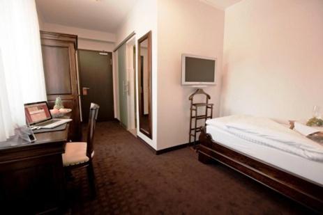 奥特鲁普阿尔索夫兰德酒店的一间卧室配有一张床、一张桌子和一台电脑