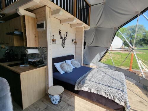 KrzemiennaGlamping nad Sanem的帐篷内的一个房间,配有一张床和一个柜台