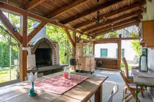 凯斯特海伊Hermann Cottage的户外厨房配有桌子和壁炉