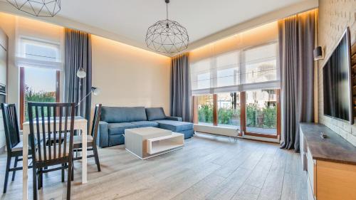 格丁尼亚Apartamenty Sun & Snow Gdynia Nowe Orłowo的客厅配有蓝色的沙发和桌子