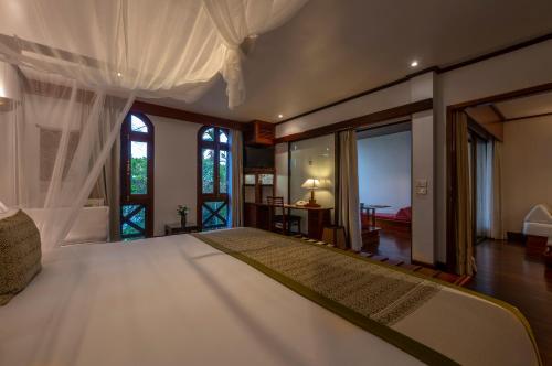 琅勃拉邦La Résidence Phou Vao, A Belmond Hotel, Luang Prabang的卧室设有一张带窗户的白色大床