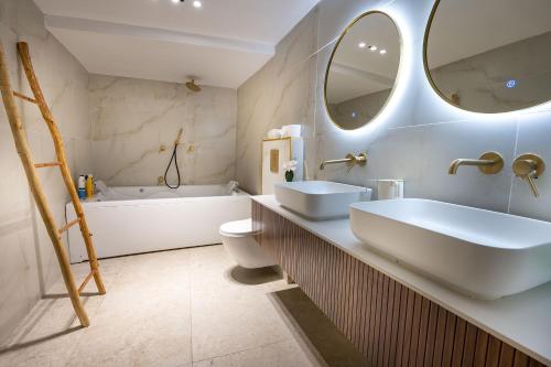 萨法德Moses Luxury Vacation Homes-מתחם פיניקס的一间带两个盥洗盆、浴缸和卫生间的浴室