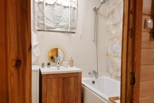 米沃姆温Domek na Skarpie的浴室配有盥洗盆和浴缸。