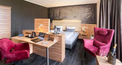 不莱梅PLAZA Premium Columbus Bremen的酒店客房,配有一张床、一张桌子和椅子
