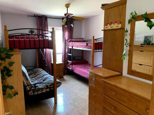 埃尔卡沃德加塔Apartamento dúplex Cabo de Gata的一间带两张双层床和梳妆台的卧室