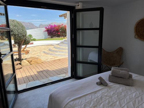 Canillas de AceitunoCasa de Pilares的一间卧室设有一张床和一个大型滑动玻璃门