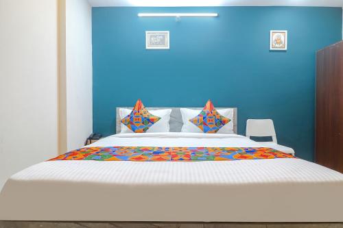 海得拉巴FabHotel Broholic Suites I的一间卧室设有一张蓝色墙壁的大床