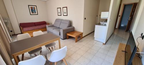 拉雷多拉雷多普拉亚公寓式酒店的客厅配有桌椅和沙发