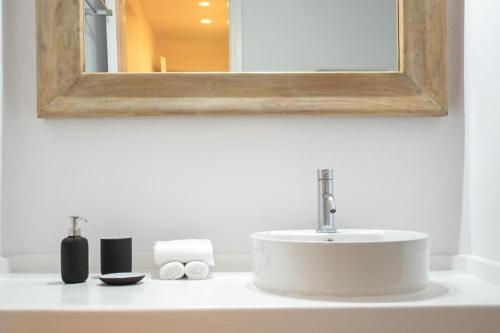 米克诺斯城Villabellum Mykonos的浴室的柜台设有水槽和镜子