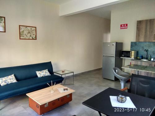 拉戈莱特APPARTMENT( LA PAPAYA)的客厅配有蓝色沙发和冰箱