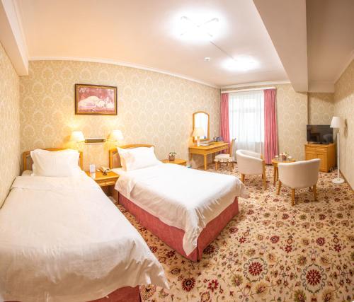 乌兰巴托Continental Hotel的酒店客房配有两张床和一张书桌