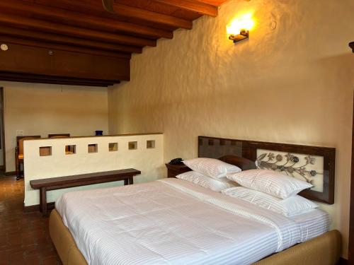 钱德加尔The Kaptain's Retreat的一间卧室配有一张带白色床单的大床