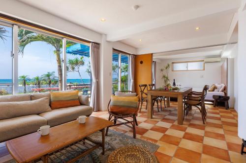 恩纳海まで徒歩1分 沖縄でも珍しい絶景ホテル 贅沢プライベートビーチ付き ビーチルーム的客厅配有沙发和桌子