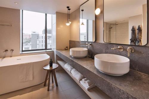 墨尔本墨尔本雷吉斯中央商务区酒店的一间带两个盥洗盆和大镜子的浴室