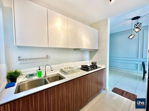 新山Seasons Luxury Apartment By Jk Home的厨房配有水槽、炉灶和橱柜。