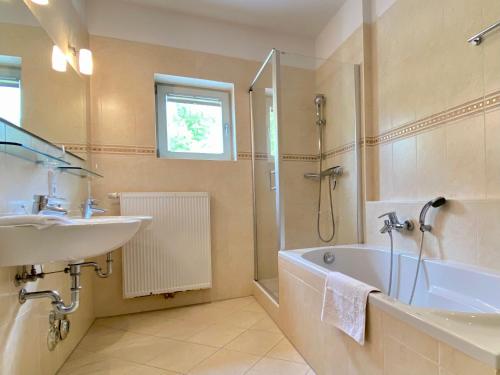 黑灵斯多夫Villa Jasmin - Ferienwohnung 7的带浴缸、水槽和淋浴的浴室