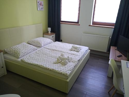 JiříkovWaldhof的一间卧室配有一张床,上面有两条毛巾