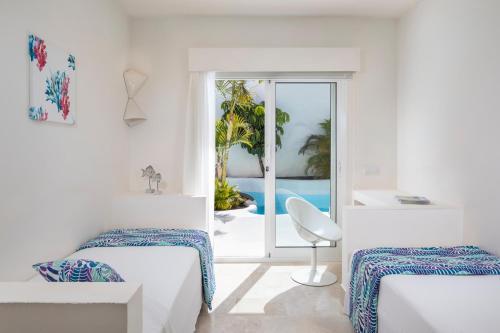 科拉雷侯Bahiazul Resort Fuerteventura的白色客房 - 带两张床和阳台