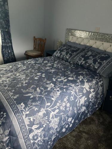 利特里姆Clinton’s cottage的一间卧室配有一张带蓝色和白色床单的床。