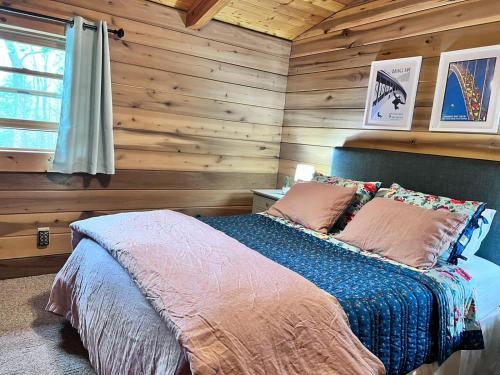 HicoBeautiful Cabin on 83 Acres near New River Gorge National Park的一间卧室设有木墙和一张带枕头的床。