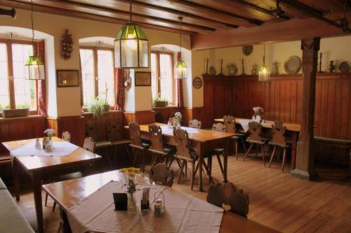 罗滕堡斯齐瓦尔兹拉姆酒店的用餐室配有木桌和椅子