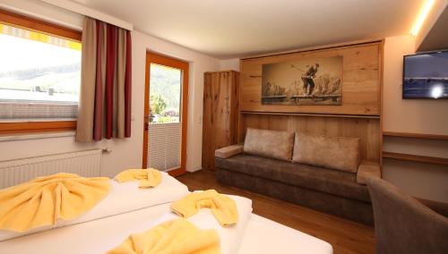 拉姆绍达赫斯坦Hotel-Appartement Hochkönig的酒店客房,设有两张床和一张沙发