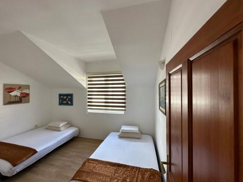 赫尔采格诺维Apartments Sun House的一间小卧室,配有两张床和窗户