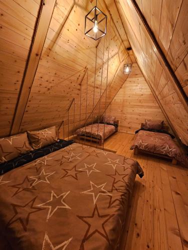 米特洛瓦克Oaza Jela的木制阁楼上的卧室配有两张床