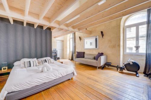 波尔多Le 22 - Magnifique appartement en plein cœur des Chartrons的一间大卧室,配有一张床和一张沙发