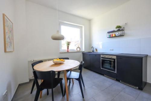 波鸿75qm Luxusapartment in perfekter Lage的厨房配有桌椅和窗户。