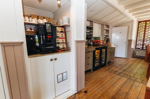 雷讷瑟Maison Bellefleur B&B - Pension的厨房铺有木地板,配有带微波炉的台面