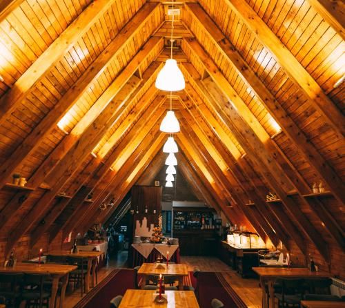 潘波洛沃Complex Malina Pamporovo的用餐室设有木桌和木制天花板。