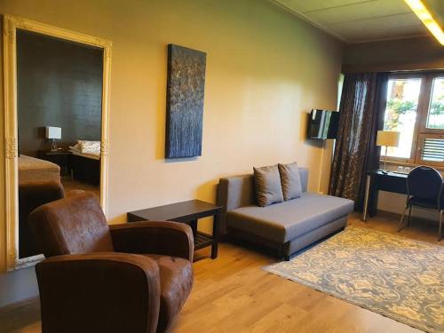 凯乌鲁Hotelli Viikinhovi的客厅配有沙发和椅子