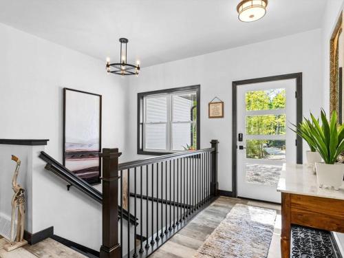 斯特金贝New, charming custom home的拥有白色墙壁的走廊和带镜子的楼梯