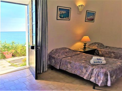 阿尔布费拉Jardins do Mar - BY BEDZY的一间卧室设有两张床,一扇通往大海的门