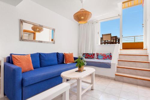 圣地亚哥港Panomaric Sea View - Sol Apartment的客厅配有蓝色的沙发和桌子