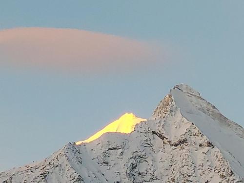卡森里德B&B Alpenrösli的雪覆盖的山,阳光照耀着
