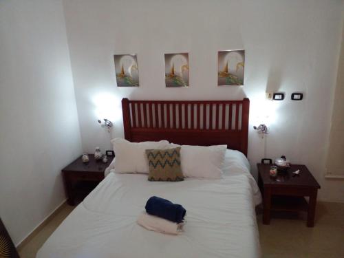 拉古纳Apartamentos y habitaciones sol dominicus SOLO ADULTOS的卧室配有一张带两张桌子的大型白色床